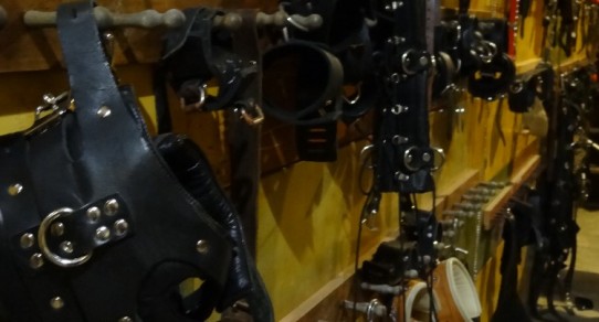Bondage equipment hung on racks at Kink Armory studio